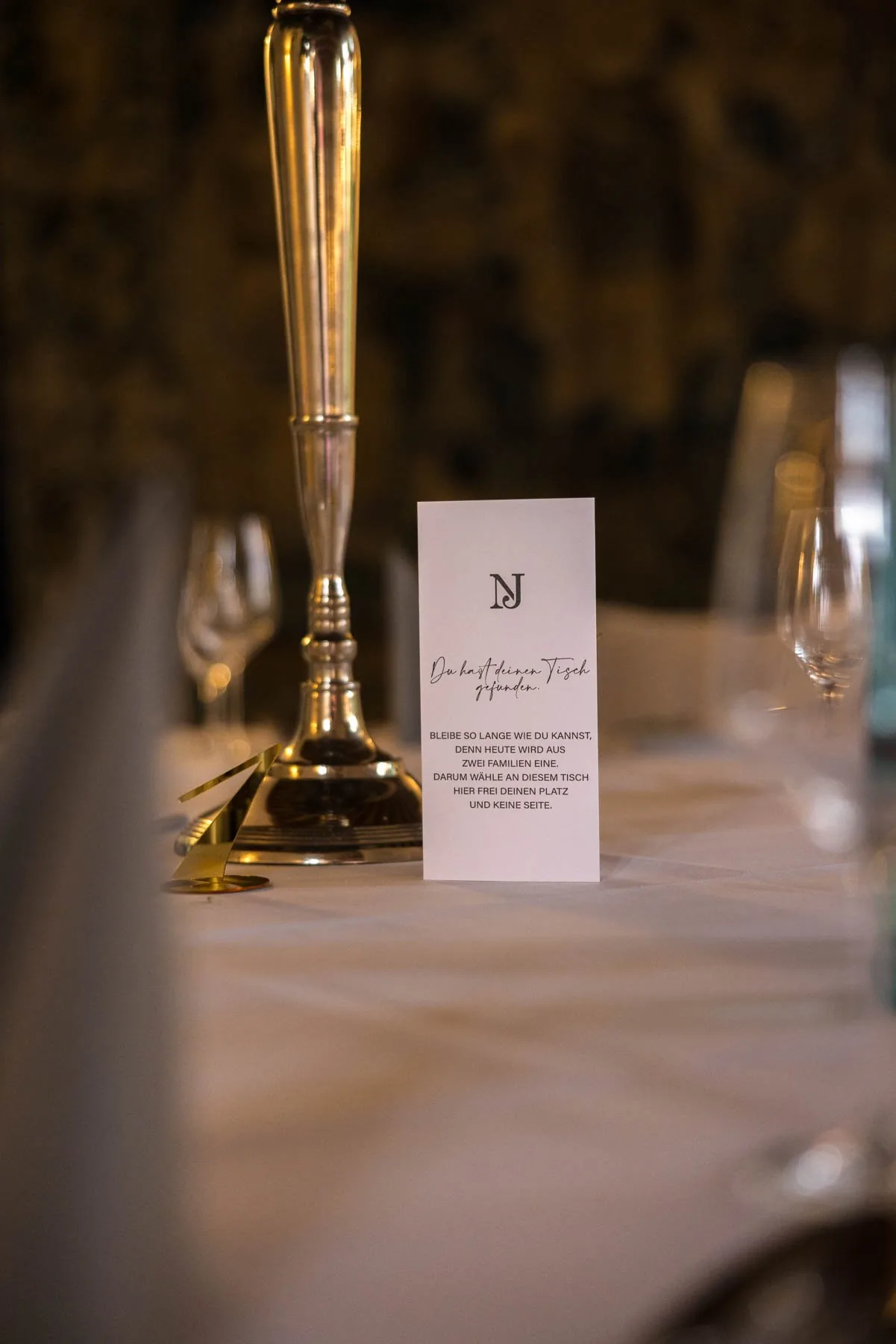 Menükarte und Messingleuchter auf der gedeckten Festtafel